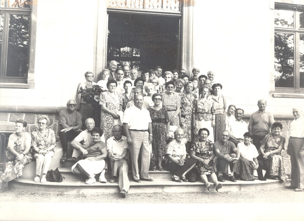 Photo de groupe en noir et blanc de retraités de la Macif sur des marches